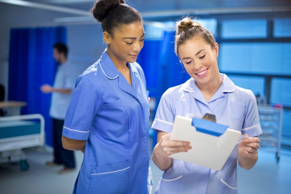 Two clinicians discussing a chart in a healthcare setting